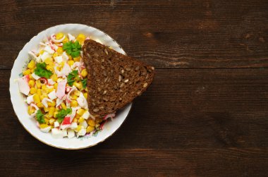 Yengeç ahşap bir masa üzerinde bir tabak salata. Rustik tarzı