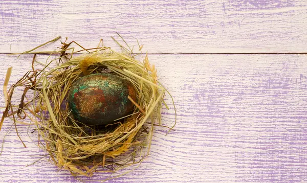 Easter eggs in the nest on wooden background. — Stock Photo, Image