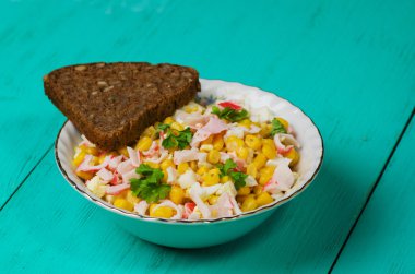 Yengeç ahşap bir masa üzerinde bir tabak salata. Rustik tarzı