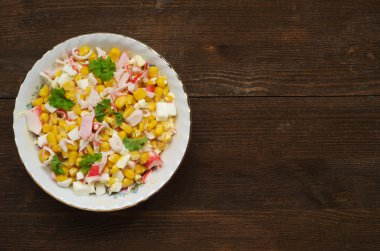 Yengeç ahşap bir masa üzerinde bir tabak salata. Rustik tarzı