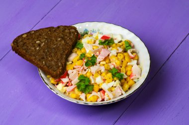 Yengeç ahşap bir masa üzerinde bir tabak salata. Rustik tarzı