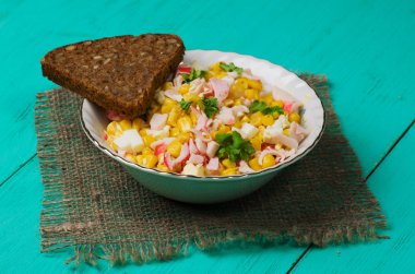 Yengeç ahşap bir masa üzerinde bir tabak salata. Rustik tarzı