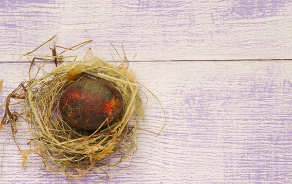 Easter eggs in the nest on wooden background. — Stock Photo, Image