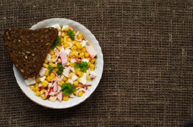 Yengeç ahşap bir masa üzerinde bir tabak salata. Rustik tarzı