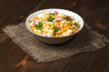 Yengeç ahşap bir masa üzerinde bir tabak salata. Rustik tarzı