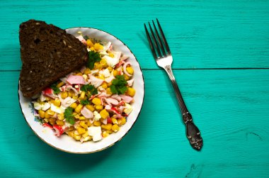 Yengeç ahşap bir masa üzerinde bir tabak salata. Rustik tarzı