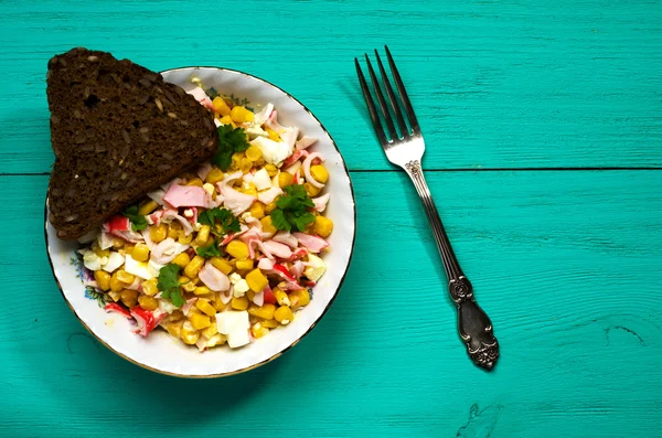 Yengeç ahşap bir masa üzerinde bir tabak salata. Rustik tarzı