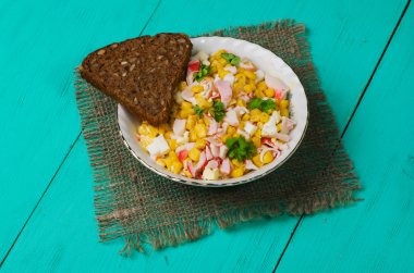 Yengeç ahşap bir masa üzerinde bir tabak salata. Rustik tarzı