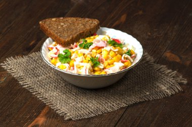 Yengeç ahşap bir masa üzerinde bir tabak salata. Rustik tarzı