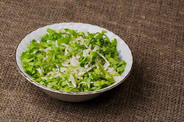 Cabbage salad in a plate on a wooden table. — Stock Photo, Image