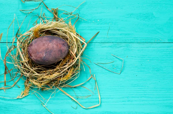 Easter eggs in the nest on wooden background. — Stock Photo, Image