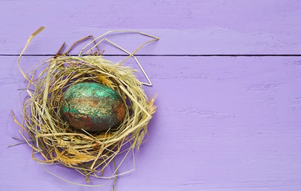 Easter eggs in the nest on wooden background. — Stock Photo, Image