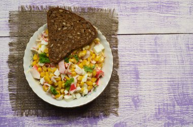 Yengeç ahşap bir masa üzerinde bir tabak salata. Rustik tarzı