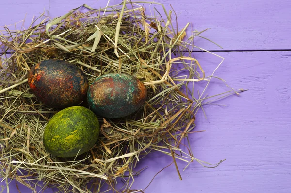 Pasen eieren in het nest op houten achtergrond. — Stockfoto