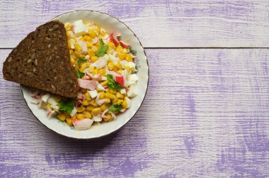 Yengeç ahşap bir masa üzerinde bir tabak salata. Rustik tarzı