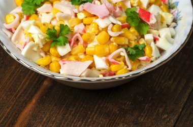 Yengeç ahşap bir masa üzerinde bir tabak salata. Rustik tarzı