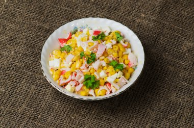 Yengeç ahşap bir masa üzerinde bir tabak salata. Rustik tarzı