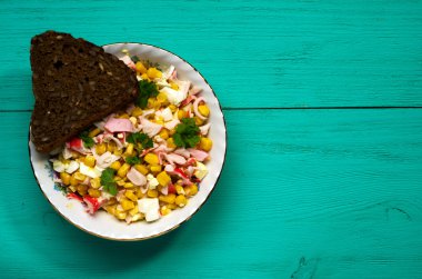 Yengeç ahşap bir masa üzerinde bir tabak salata. Rustik tarzı