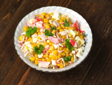 Yengeç ahşap bir masa üzerinde bir tabak salata. Rustik tarzı