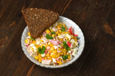 Yengeç ahşap bir masa üzerinde bir tabak salata. Rustik tarzı