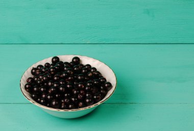 Ahşap arka planda siyah frenk üzümü.