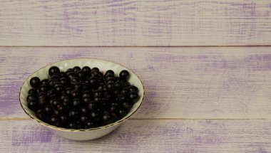 Ahşap arka planda siyah frenk üzümü.