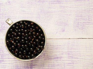 Ahşap arka planda siyah frenk üzümü.