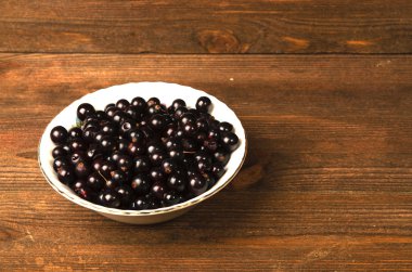 Ahşap arka planda siyah frenk üzümü.