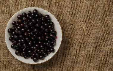 Ahşap arka planda siyah frenk üzümü.