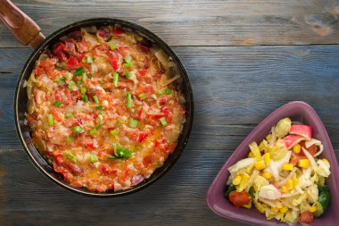 Gri mavi ahşap arka planda soğanlı haşlanmış domatesler. Metal tepsi manzaralı soğanlı haşlanmış domates. Vejetaryen yemeği.