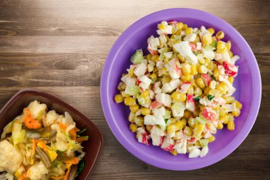 Mor tabakta sebze salatası manzaralı yengeç salatası. Kahverengi ahşap arka planda yengeç salatası