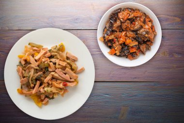 Mor ahşap arka planda beyaz tabakta Berlin salatası. Sosis, salatalık, biber soslu salata. .