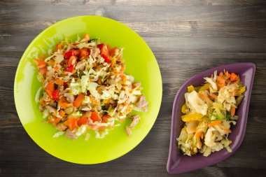 Tavuk mideli salata ile sebze havuç, soğan, biber, lahana, domates, brokoli. Limonlu tavuklu salata, siyah ahşap arka plan manzaralı.