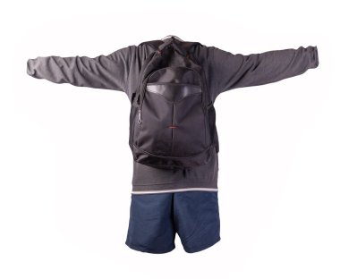 Siyah sırt çantası, gri beyaz kazak, beyaz arka planda koyu mavi şort. Spor giyimi