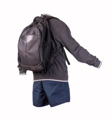 Siyah sırt çantası, gri beyaz kazak, beyaz arka planda koyu mavi şort. Spor giyimi