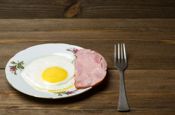 sahanda yumurta ahşap arka plan üzerinde bir tabakta kadar güneşli tarafı.