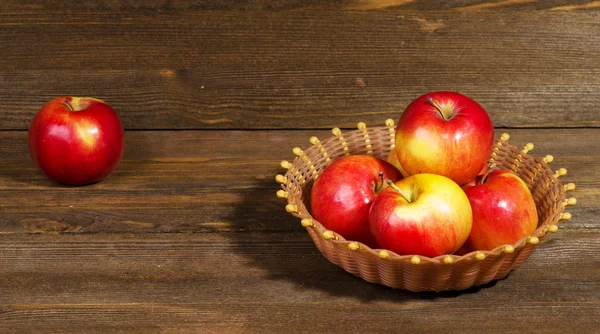 Φρέσκα μήλα σε ένα ξύλινο τραπέζι στο παρασκήνιο — Φωτογραφία Αρχείου