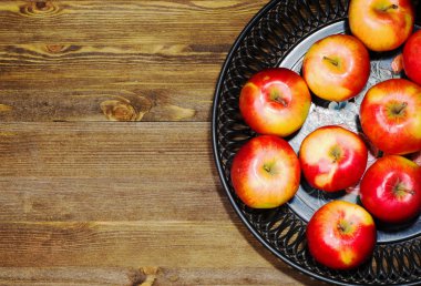 içinde belgili tanımlık geçmiş ahşap bir masa üzerinde taze elma