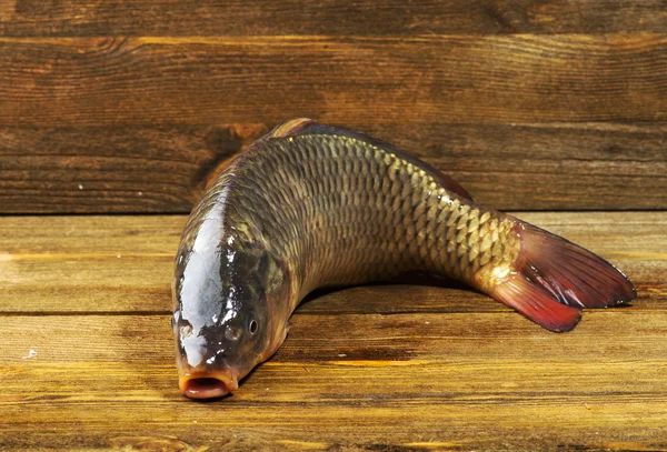 Raw fish on wooden table as background — Stock Photo, Image