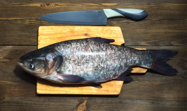 Arka plan olarak ahşap masa üzerinde çiğ balık — Stok fotoğraf