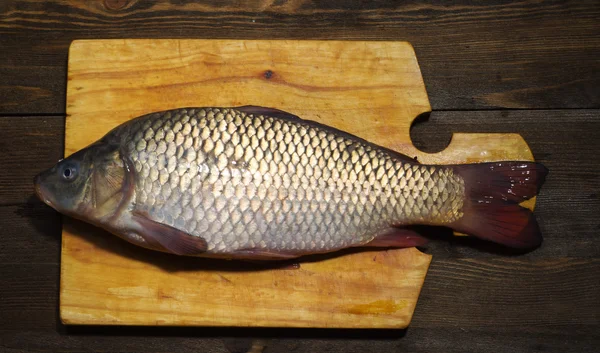 Peixe cru na mesa de madeira como fundo — Fotografia de Stock