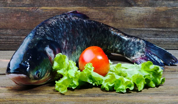 Raw fish on wooden table as background — Stock Photo, Image