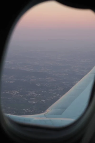Sunset through the window of an airplane taking off from Porto, Portugal
