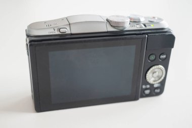 Modern tasarım aynasız dijital kamera. Sırtı beyaz bir masaya dönük.