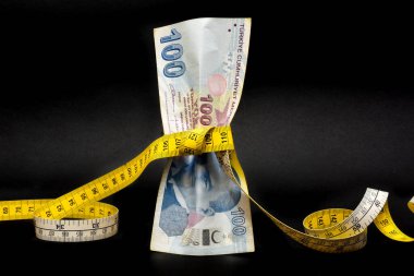 Türk lirası ölçü bandıyla sıkılaştırılır. Türkiye 'nin lira krizi. Türk lirası düşüyor ve kilo veriyor. Türk ekonomisi çöküyor, çöküyor. Enflasyon, borç ve gümrük tarifesi kavramı.