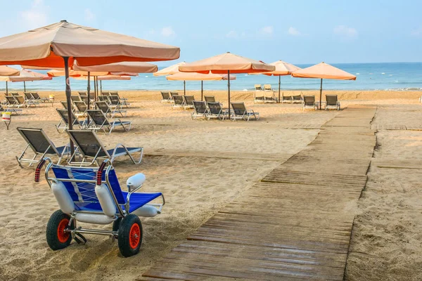 Beach wheel chair for disabled swimmers near The Mediterranean sea in hotel. Resort - vacation concept.  Summer holidays.  Outdoor activities on the beach in summer.