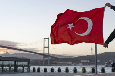 Türk Bayrağı, 15 Temmuz Şehitler Köprüsü (Türkçe: 15 Temmuz Sehitler Koprusu) veya İstanbul 'daki Boğaz Köprüsü' nün önünde bir siluet duruyor. Vatanseverlik kavramı.