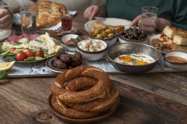 Lezzetli zengin geleneksel Türk kahvaltısı arasında domates, salatalık, peynir, tereyağı, yumurta, bal, ekmek, simit, zeytin ve çay fincanları yer alıyor. Ramazan Suhoor diğer adıyla Sahur (oruç tutmadan önce sabah yemeği). 