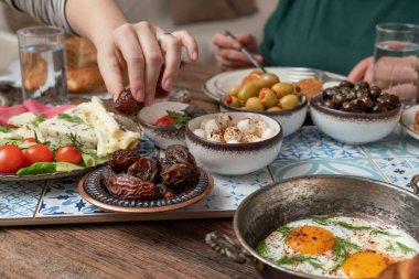 Lezzetli zengin geleneksel Türk kahvaltısı arasında domates, salatalık, peynir, tereyağı, yumurta, bal, ekmek, simit, zeytin ve çay fincanları yer alıyor. Ramazan Suhoor diğer adıyla Sahur (oruç tutmadan önce sabah yemeği). 