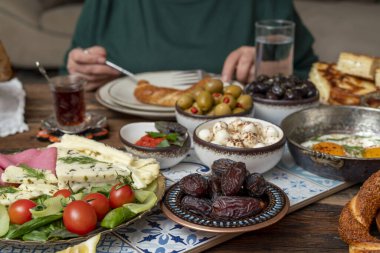 Lezzetli zengin geleneksel Türk kahvaltısı arasında domates, salatalık, peynir, tereyağı, yumurta, bal, ekmek, simit, zeytin ve çay fincanları yer alıyor. Ramazan Suhoor diğer adıyla Sahur (oruç tutmadan önce sabah yemeği). 
